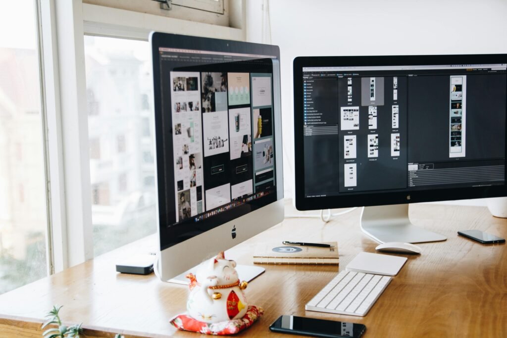 pexels-photo-326502-326502 A sleek modern office setup featuring dual monitors, Apple devices, and creative decor in an indoor workspace.